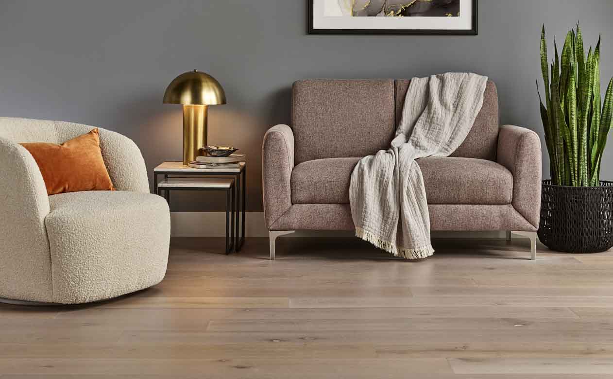 Light hardwood floor with beige sofa. 